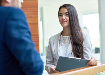 Young woman in a modern office holding a clipboard